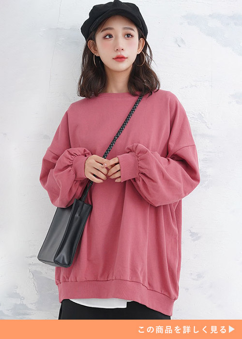 ピンクのトレーナーを着る女性