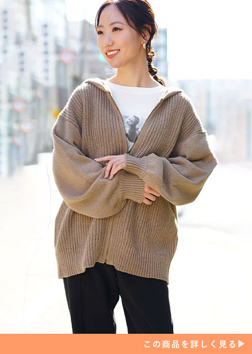 モカ色のニットジップパーカを着る女性