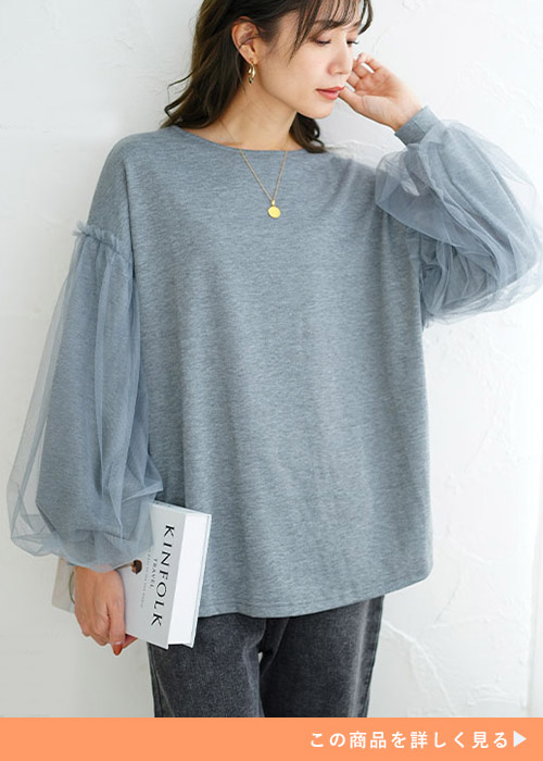 チュールを重ねたふんわり袖デザインのグレー色トレーナーを着る女性