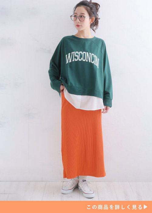 グリーンのシャツレイヤード風ロゴトップス×オレンジのナロースカートを着る女性