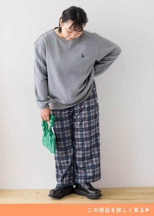 グレーのトレーナー×チャコールのチェック柄パンツを着る女性