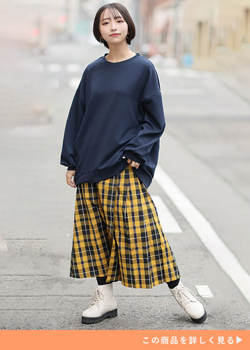 ネイビーのトレーナー×イエローのチェック柄スカートを着る女性