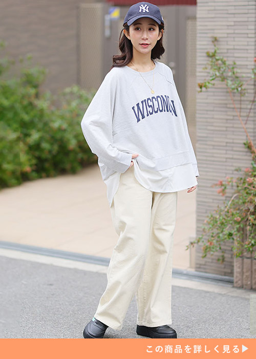 オートミール色のロゴトレーナー×アイボリー色のパンツを着る女性