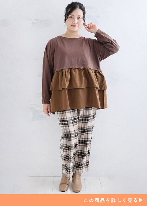 ブラウンのティアードトップス×ブラウン系のチェック柄パンツを着る女性