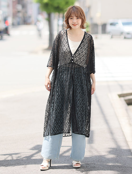 白色ノースリーブ×淡色デニムに、黒色のレースカーディガンを着る女性