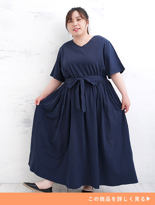 リボンベルトがポイントのネイビーのフレアワンピースを着た女性