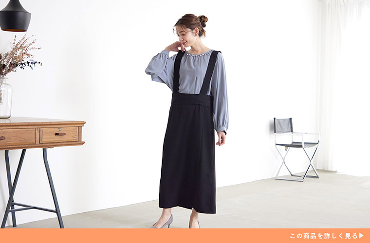 水色のブラウス×Iラインの黒色のジャンスカを着る女性