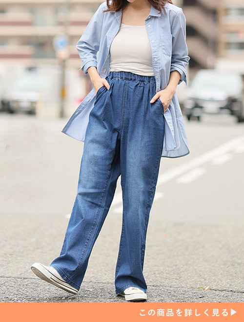 ベージュのトップス×デニムパンツに、水色のロングシャツを羽織る女性