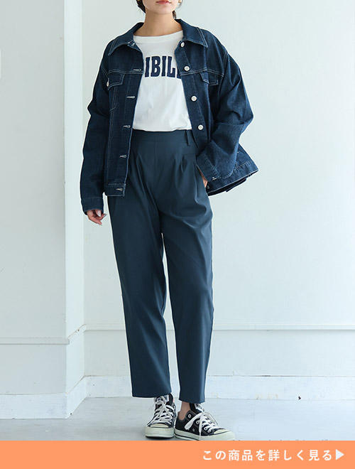 白のロゴT×ブルーグレーのテーパードパンツにデニムジャケットを羽織る女性