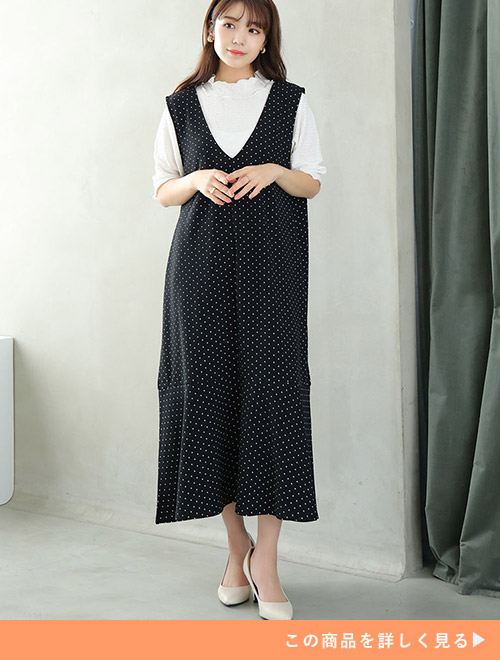 白トップス×黒のドット柄ジャンスカを着る女性