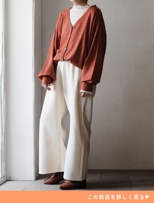 白のレーストップス×ブラウンのカーディガンに、アイボリーのカーブパンツを履く女性