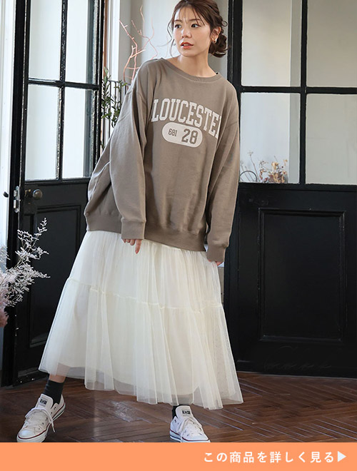 ブラウンのカレッジロゴトップス×アイボリーのチュールスカートを着る女性