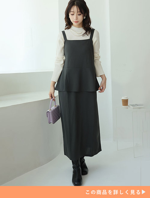 白のタートルネックニット×チャコールグレーのペプラムワンピを着る女性