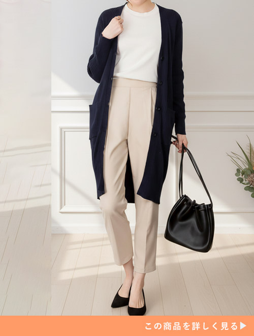 白トップス×ベージュのパンツに、ネイビーのロングカーディガンを羽織る女性