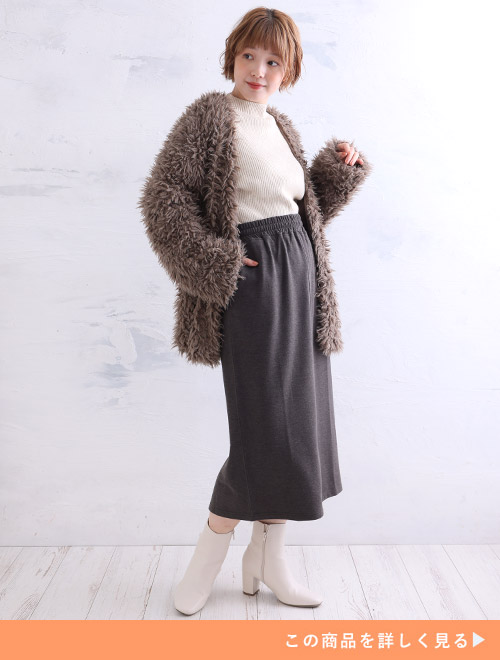 チャコールのタイトスカートとホワイトリブトップのコーデに、ブラウンのカーディガンを羽織る女性