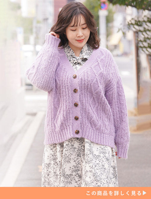小花柄ワンピースにグレイッシュパープルのニットカーディガンを羽織る女性