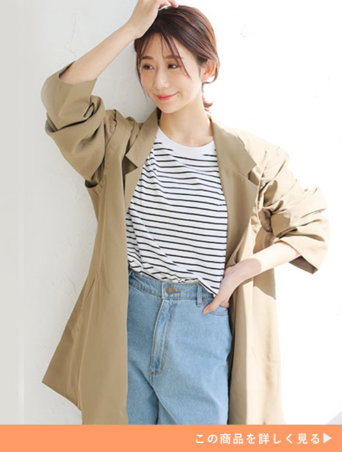 デニムパンツとボーダートップスのコーデに、カーキベージュのテーラードジャケットを羽織る女性