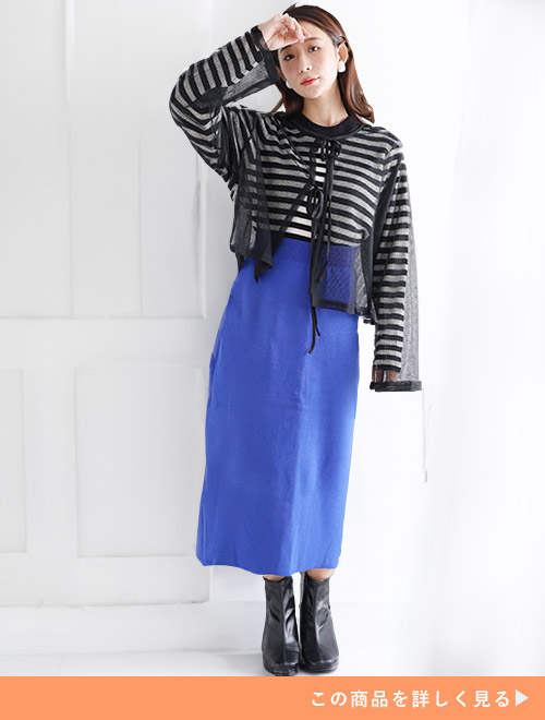 ボーダートップスとブルータイトスカートのコーデに、ブラックのシアーカーディガンを羽織る女性