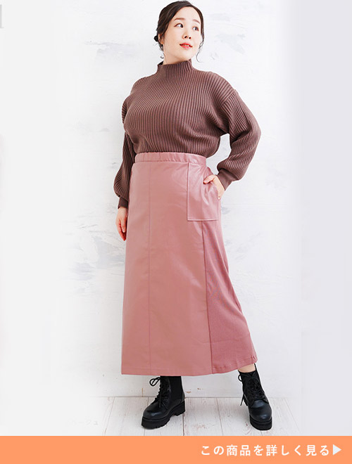 ピンクベージュスカートとブラウンリブトップスのコーデに、ブラックブーツを履く女性