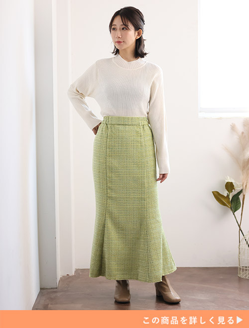 グリーンのマーメイドスカートに、白のリブニットをインした女性