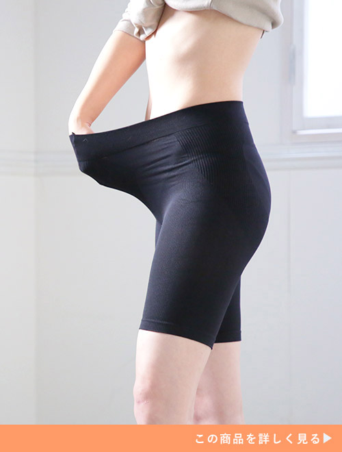 太もも丈の黒い補正下着を履く女性