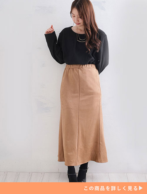 ブラックのカットソーをキャメルのマーメイドスカートにインして履く女性