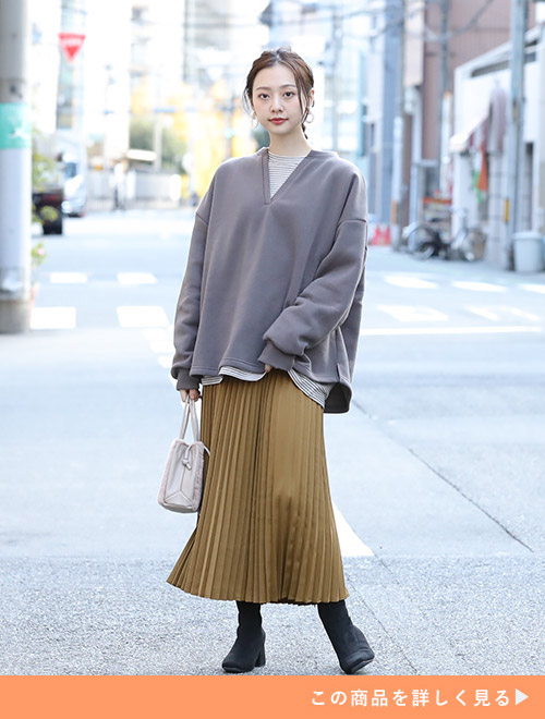 ブラウン系トップス×キャメルのプリーツスカートのワントーンコーデを着る女性