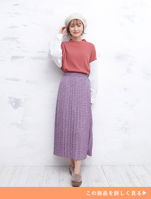 スモークパープルのプリーツスカートに、白シャツ×くすみピンクのドッキングトップスをタックインして着る女性