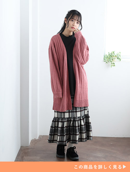 黒トップス×黒系のチェック柄マーメイドスカートに、くすみピンク色のロングカーディガンを羽織る女性。