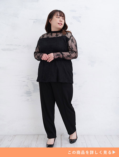 肩から袖にかけてレース素材の黒トップス×黒パンツのブラックコーデをする女性