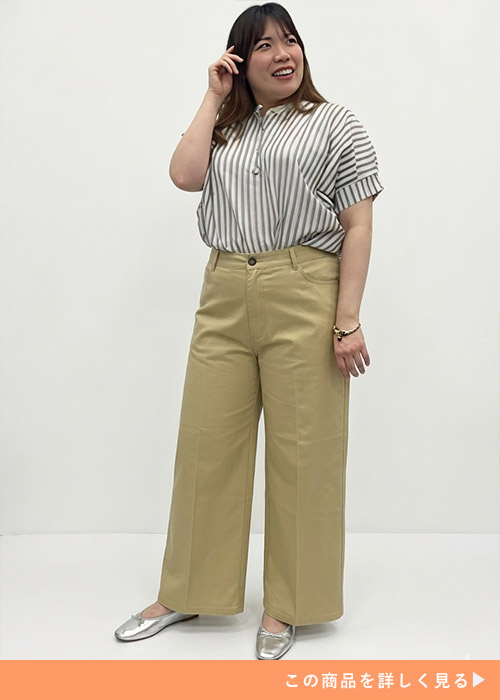 ベージュのワイドパンツにストライプシャツを着たぽっちゃり女性