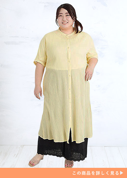 ブラックのワイドパンツを履いて黄色のシャツワンピースを着る女性