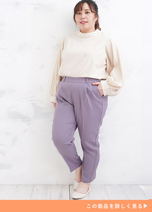 ライラックのテーパードパンツにベージュのトップスを着たぽっちゃり女性