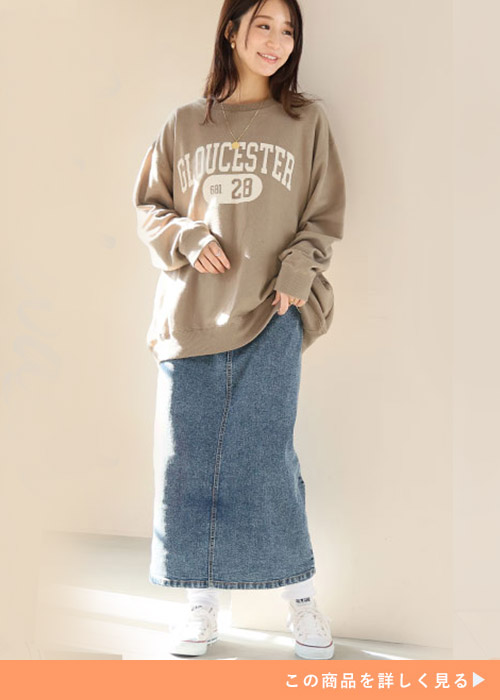 ケミカルデニムのタイトスカートにベージュのロゴトップスを着た女性