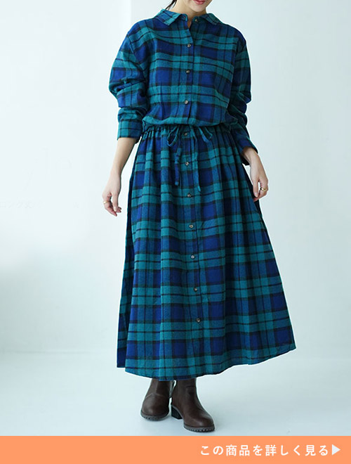 グリーン系チェックシャツワンピースのウエストを絞って着用する女性