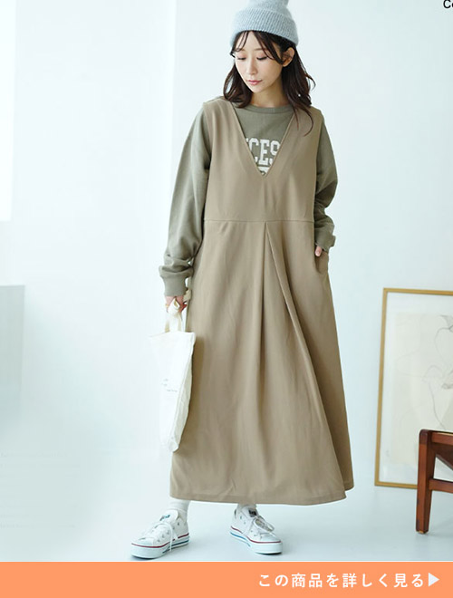 ライトカーキのトレーナーにベージュのタックスカートを合わせる女性