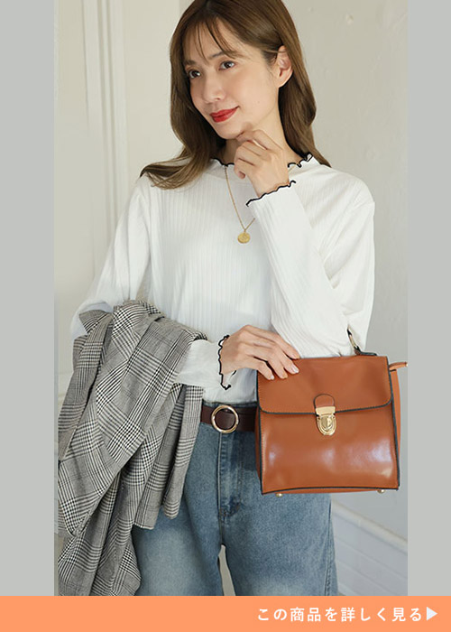 オフホワイトのメロウリブトップス×デニムを着て、ジャケットを手に持つ女性