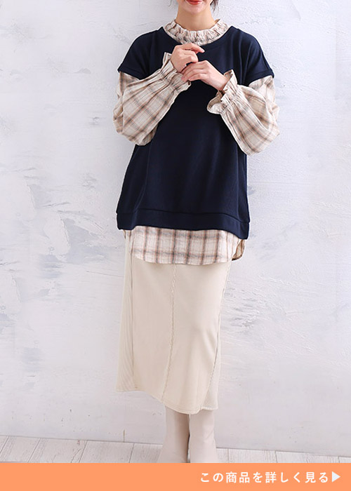 ベージュ系チェック柄ブラウス×ネイビーのベストを着て、アイボリーのタイトスカートを履く女性