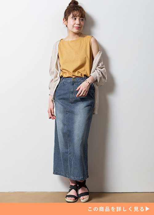 オレンジのタンクトップ×デニムのタイトスカートに、ゴールドのシアーカーディガンを羽織る女性