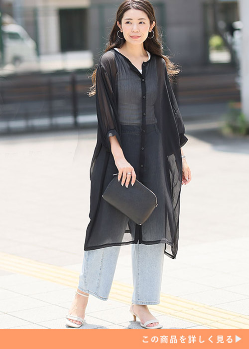 白タンクトップ×淡色デニムパンツに、黒のシアーワンピを重ね着する女性