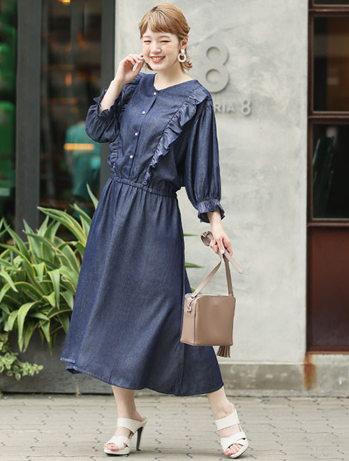 ネイビーのデニム調ワンピースを着る女性