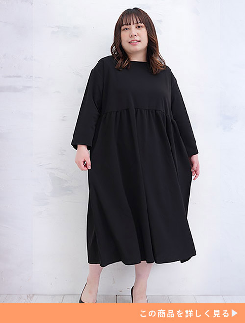 胸下に切り替えギャザーのある黒色のワンピースを着る女性