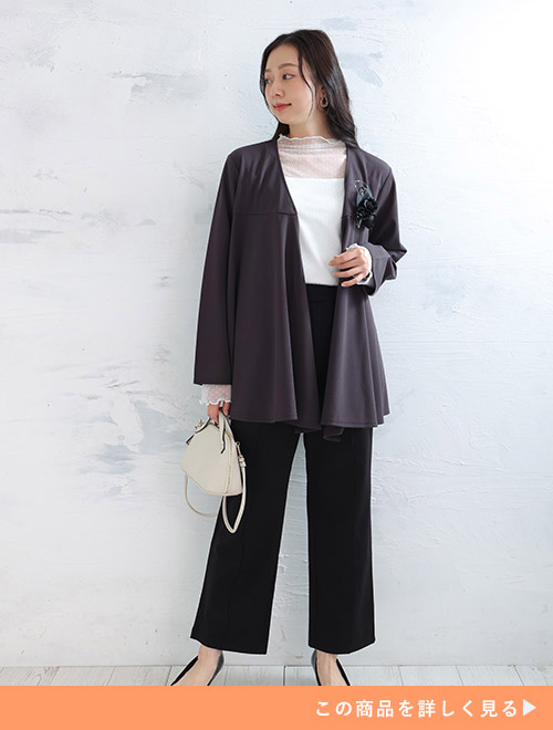 白のシアートップス×黒パンツにチャコール色のジャケットを羽織る女性