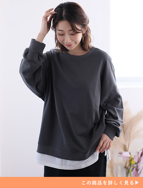 オーバーサイズのルオーバーを着て、黒のスカートを履く女性