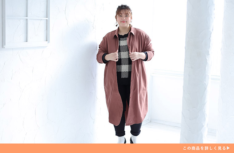 格子柄の白黒トップス×黒パンツに、モカピンク色のシャツワンピースを羽織る女性