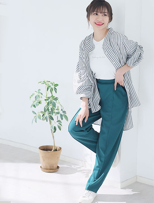 白Tシャツ×緑のテーパードパンツに、ストライプ柄のオーバーサイズシャツを羽織る女性
