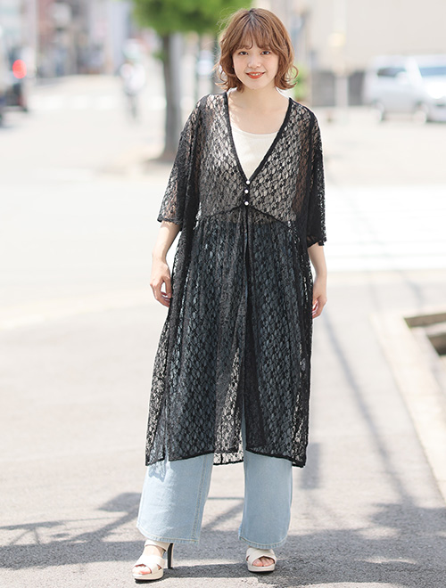 白トップス×淡色デニムに、レースのロング丈黒カーディガンを羽織る女性