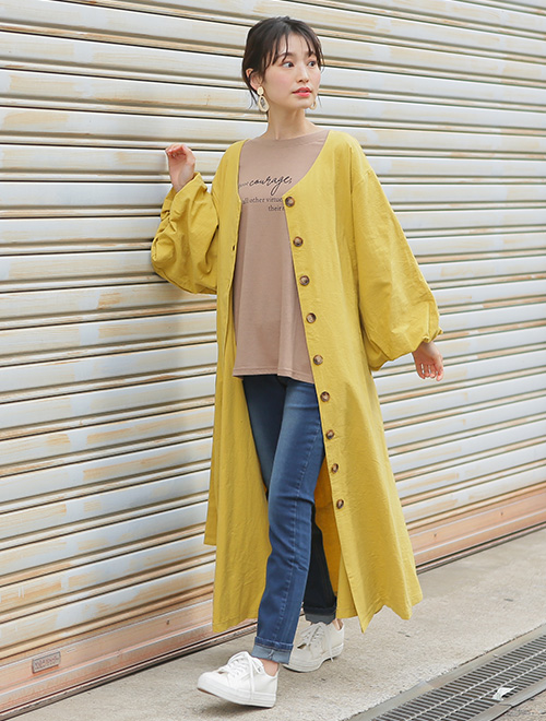 ベージュのTシャツ×スキニーデニムに、マスタードイエローのシャツワンピを羽織る女性