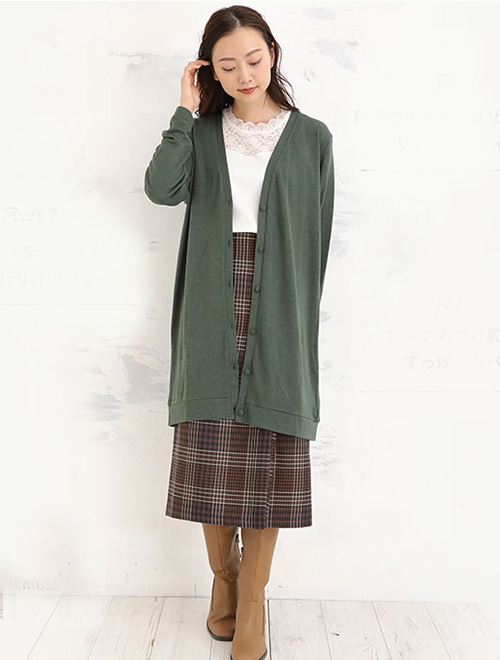 レーストップスとチェック柄タイトスカートのコーデに、グリーンのロングカーディガンを羽織った女性