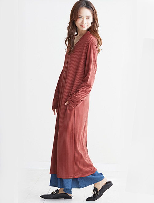 Vネックのリブロングカーディガンをワンピース風に着た女性